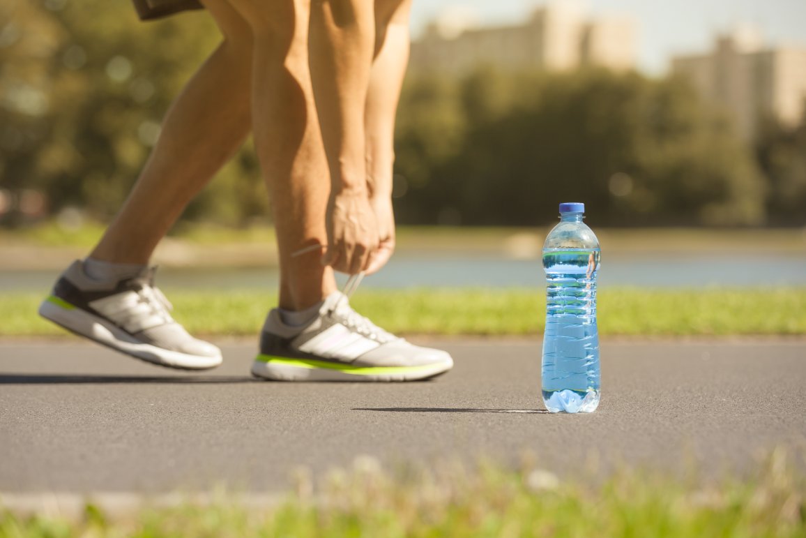 PET bottle in front of the shoes of an athlete