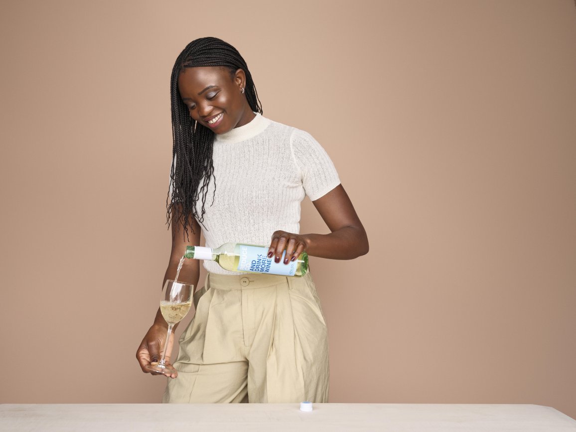 Woman fills a glass with wine.
