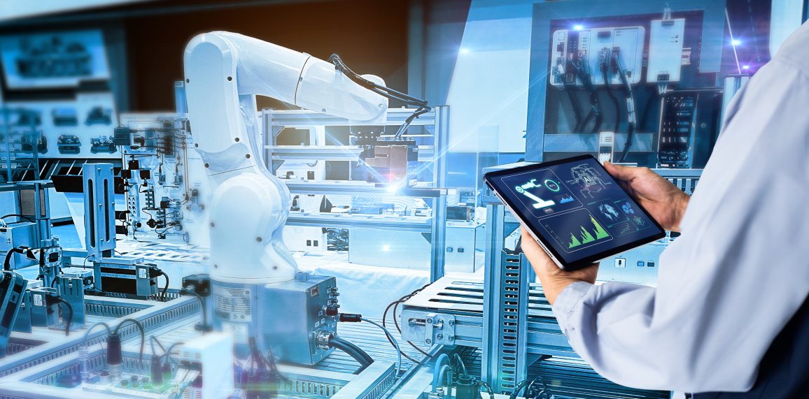 Ein Ingenieur überwacht einen automatisierten Roboterarm in einer Hightech-Verpackungsproduktionsanlage.