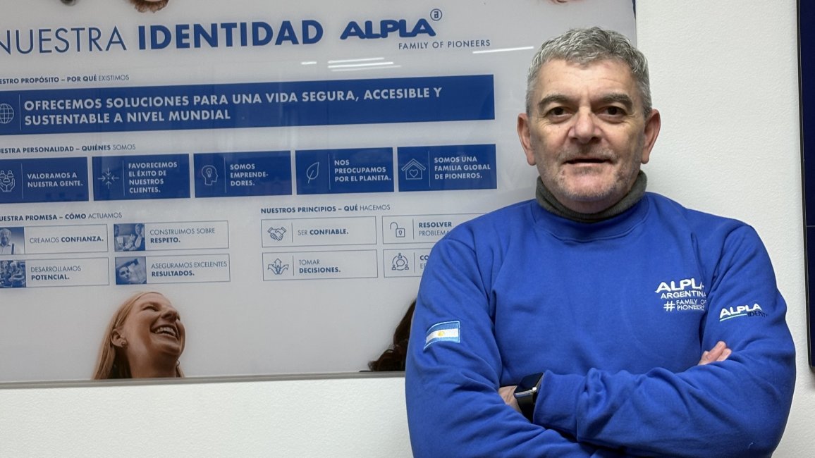 Gabriel Sanchez vor einem Plakat mit dem ALPLA-Logo. 