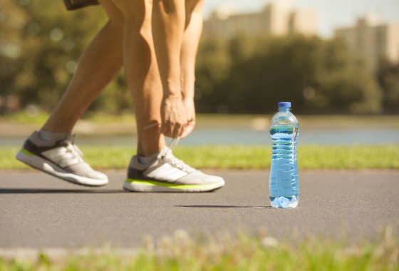 PET bottle in front of the shoes of an athlete