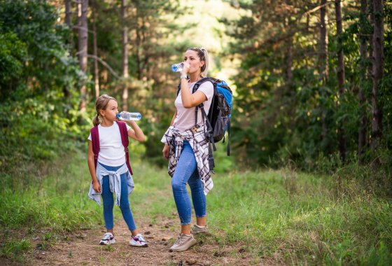 Child and Women are hiking and drinking from PET bottles