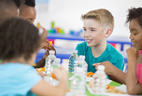 School kids sitting at a table with PET bottles