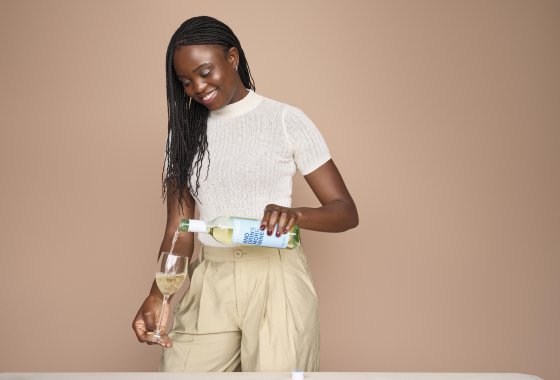 Woman fills a glass with wine.