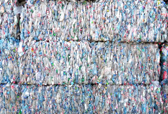 Stacked bales of compressed, multicolored PET bottles ready for recycling at ALPLArecycling.