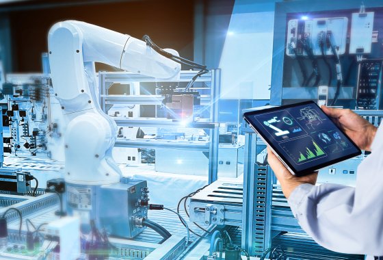 Ein Ingenieur überwacht einen automatisierten Roboterarm in einer Hightech-Verpackungsproduktionsanlage.